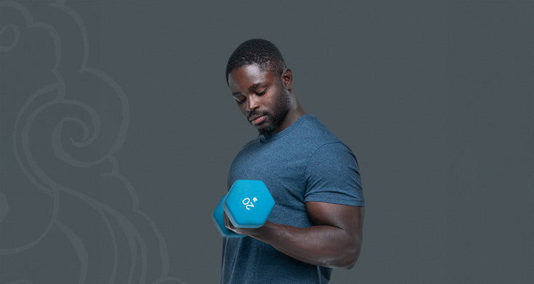 Man lifting a dumbell performing a bicep curl showing his bicep muscle in use