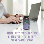 Bottle of Sunwarrior Focus & Balance supplement with two capsules on a white table, person typing on a laptop in the background, text highlighting stimulant free, soy free, gluten free, dairy free, plant-based, and vegan attributes.