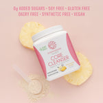Container of Sunwarrior Core Cleanser with pineapple slices and powder scoop on pink background