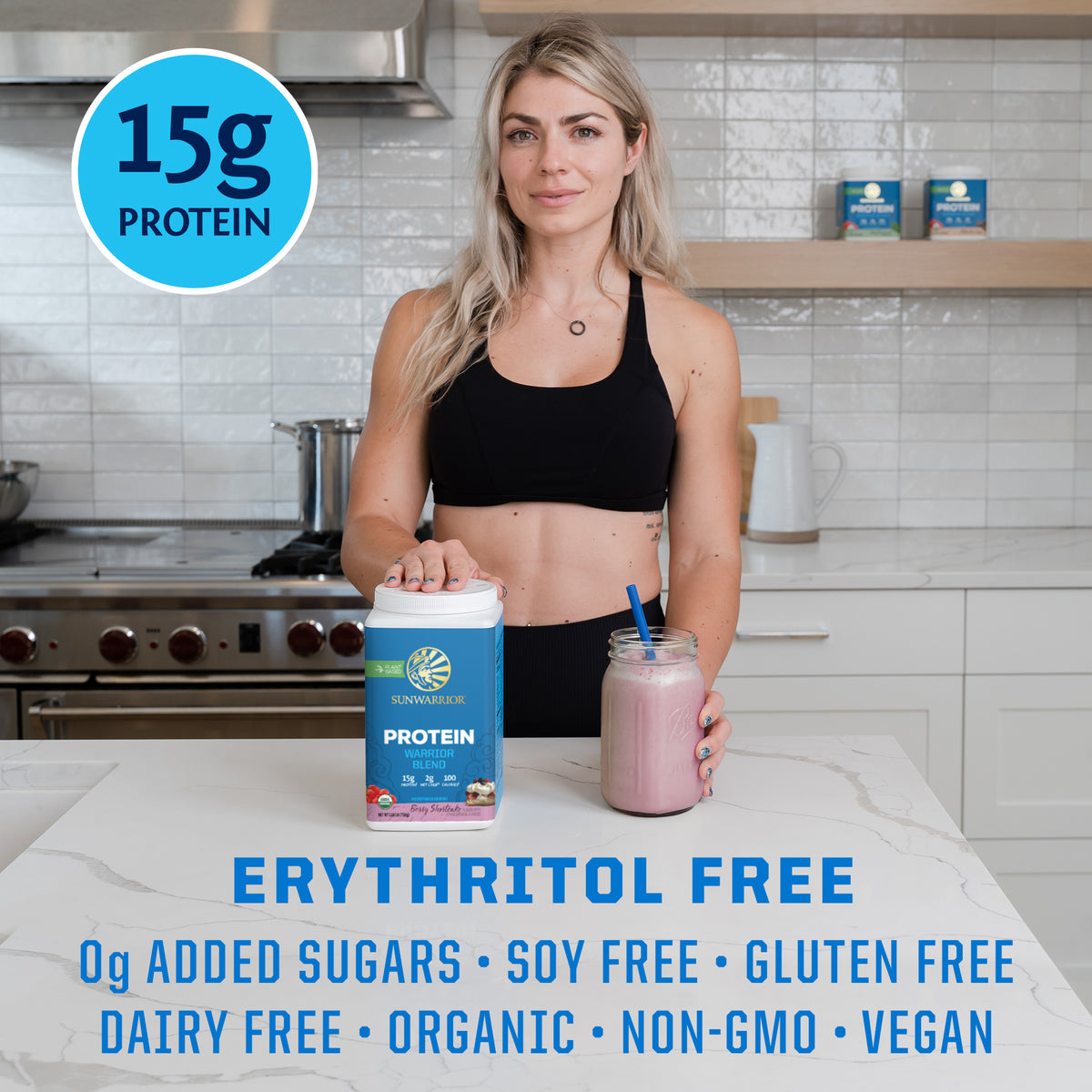 Woman in workout clothes holding a jar of pink protein shake and a container of plant-based protein powder on kitchen counter