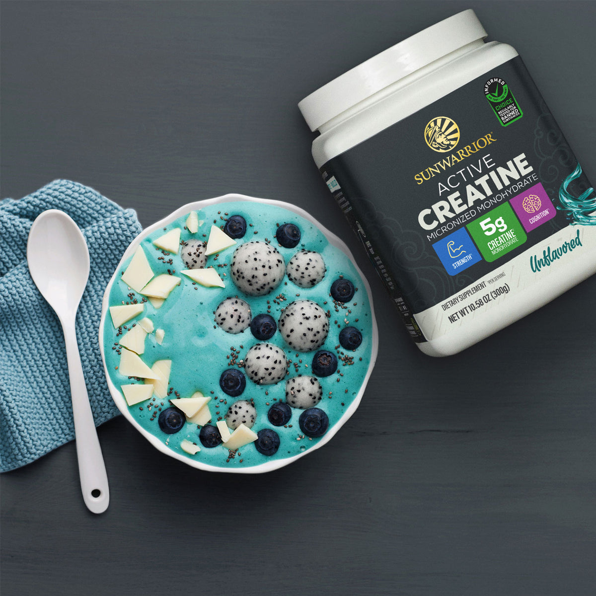 Sunwarrior Active Creatine container beside a blue smoothie bowl with fruit and white chocolate pieces