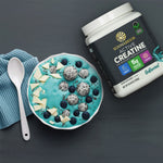 Sunwarrior Active Creatine container beside a blue smoothie bowl with fruit and white chocolate pieces