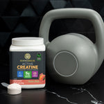 Container of Sunwarrior active creatine powder next to a grey kettlebell on a dark surface