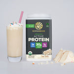 Container of Sunwarrior organic active protein powder beside a vanilla milkshake with sprinkles and cake slices