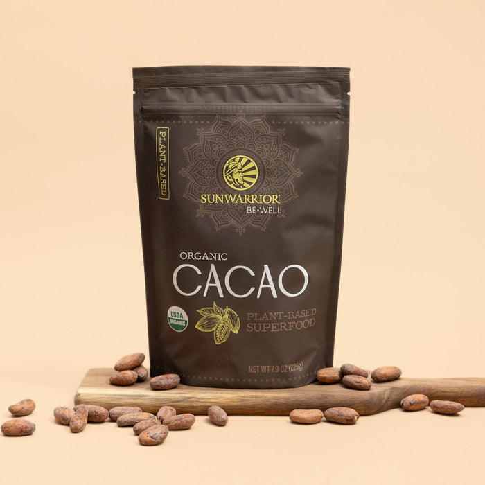 Sunwarrior Organic Cacao package on a beige background with cacao beans around