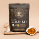 Package of organic golden milk powder with turmeric and adaptogenic nourishment beside mushroom and bowl of turmeric powder