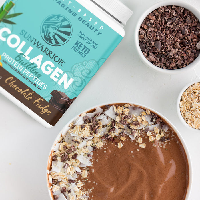 Sunwarrior collagen powder container, chocolate smoothie bowl with oats and cacao nibs on white table