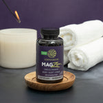 Bottle of vegan dietary supplement on wooden dish with candle and rolled towels beside it
