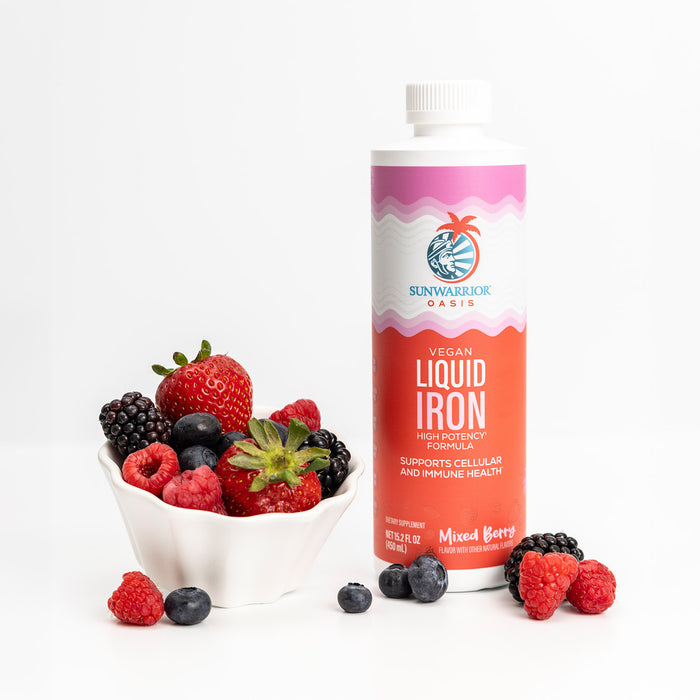 Bottle of Sunwarrior Oasis Liquid Iron along with a bowl of berries, denoting the Mixed Berry Flavor