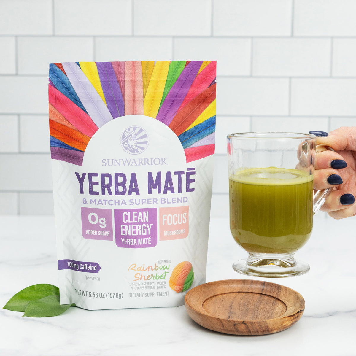 Sunwarrior Yerba Mate & Matcha Super Blend package with a glass of green tea on a white tiled background