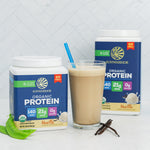 Two containers of Sunwarrior organic vanilla plant-based protein powder with a glass of vanilla smoothie and vanilla pods.