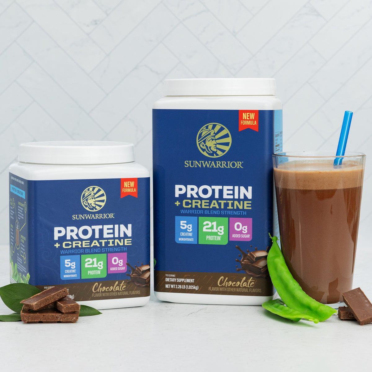 Two Sunwarrior chocolate protein containers with creatine and a glass of chocolate smoothie with green pods.