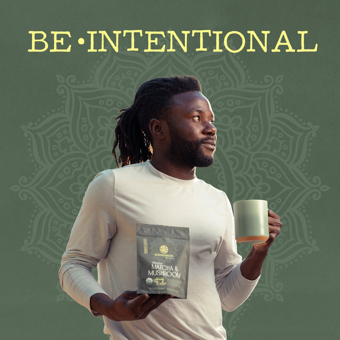 Man holding a matcha and mushroom wellness powder packet and green mug against mandala background