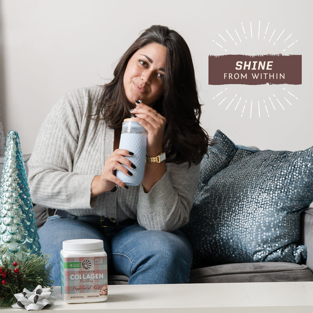 Woman sitting on couch drinking from bottle with collagen supplement and holiday decor nearby