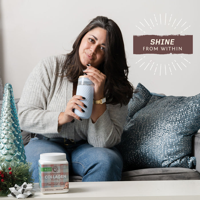 Woman sitting on couch drinking from bottle with collagen supplement and holiday decor nearby