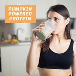 Woman in black sports bra drinking a green protein shake with pumpkin powered protein text visible