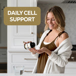 Woman in a kitchen holding a bottle of NMN with text 'Daily Cell Support'.