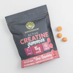 Black and pink pouch of Sunwarrior creatine gummies with three orange gummies beside it